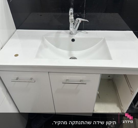 כיור לבן עם ארון פתוח מתחתיו